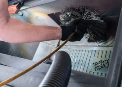 Artisan en train de ramoner un insert de cheminée